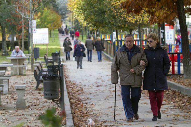 Un hombre y una mujer pasean por un parque de Vigo.