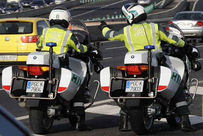 Dos guardias civiles cruzan el puente de Rande empujando la furgoneta averiada