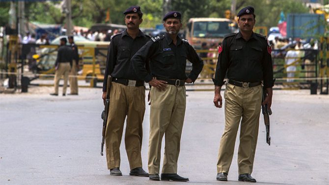 Policías paquistaníes hacen guardia cerca del lugar de un atentado contra un vehículo de las fuerzas de seguridad en la ciudad Fateh Jang, Pakistán