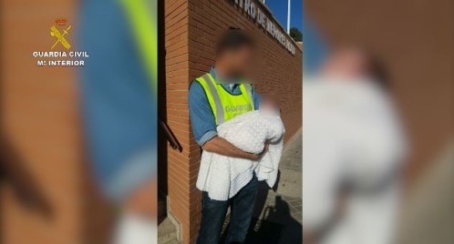 Un Guardia Civil sostiene en brazos al bebé de 3 días