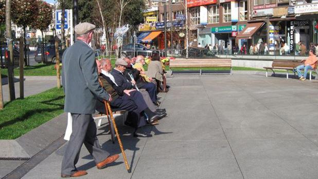 Un grupo de jubilados toma el sol en una plaza de Madrid