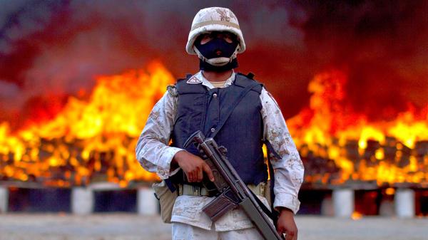 Un soldado custodia la quema de paquetes de marihuana en Tijuana, en cotubre de 2010