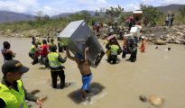 Venezolanos cruzan la frontera con Colombia por el río Táchira cargados de enseres