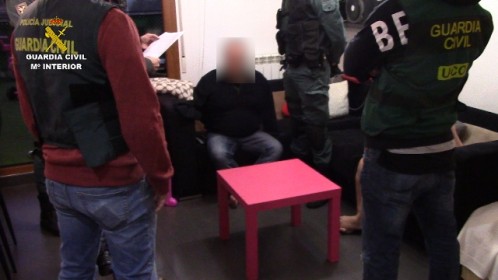 Los agentes custodian a uno de los tres detenidos 