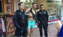 Dos policías federales acceden a tomarse fotos con un turista, mientras que uno de ellos le permite posar con su rifle de asalto reglamentario, aparentemente descargado