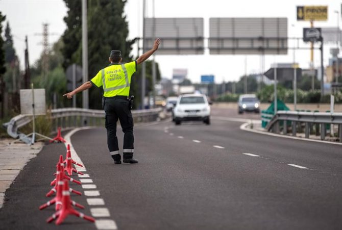 Un agente de la Guardia Civil de Tráfico da el alto a un conductor en un control.