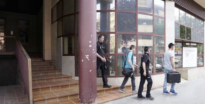 Agentes de la Policía abandonan el edifico donde se produjo el supuesto intento de homicidio (Foto El País).