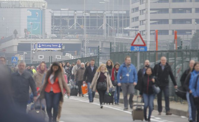 Los pasajeros evacúan la zona aeroportuaria tras registrarse explosiones en el aeropuerto internacional de Zaventem, cerca de Bruselas. 