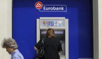 Una mujer utiliza un cajero de Eurobank en Atenas, Grecia.