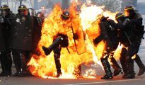 Policías franceses antidisturbios envueltos en llamas durante los enfrentamiento de París por el Primero de Mayo