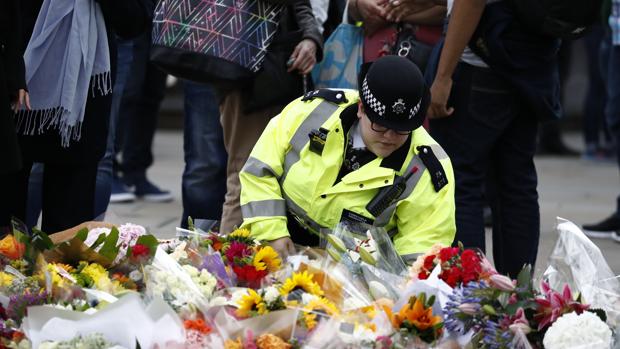 Una agente de policía deposita un ramo de flores en el lugar del atentado en Londres