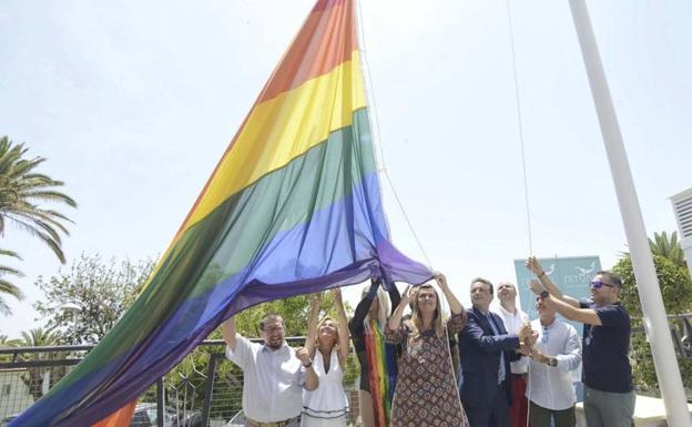 Autoridades locales despliegan una gran bandera con los colores arcoiris.