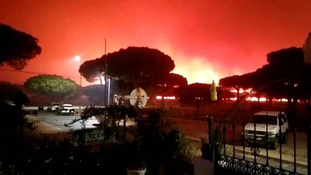 Vista del fuego próximo a viviendas en el cinturón de Doñana