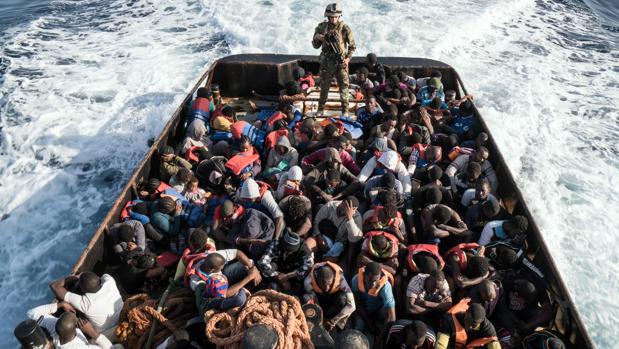 Un guardacostas libio, en pie a bordo de un bote durante el rescate de 147 ilegales que se dirigían a Europa