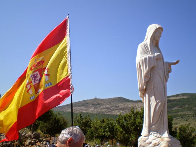 Peregrinos españoles colocan una bandera nacional junto a la Virgen de Medjugorje (Bosnia-Herzegovina). 