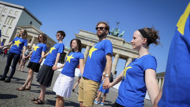 Miembros de una organización juvenil se congrega frente a la Puerta de Berlín para defender el futuro de la Unión Europea.
