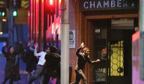 Un grupo de personas huye con las manos arriba del café Lindt durante una toma de rehenes en Sídney, Australia, el 16 de diciembre de 2014.