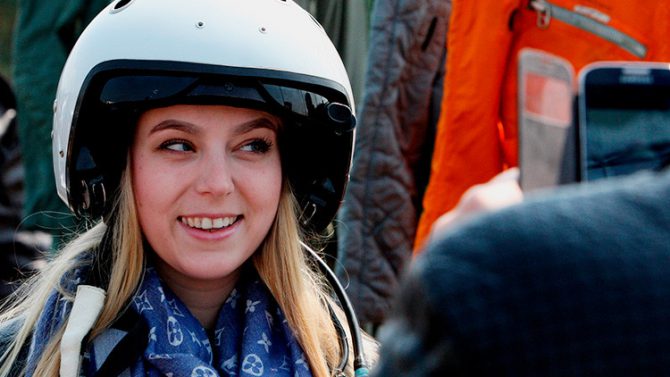 Una mujer posa con un casco de piloto en una exposición de equipamiento militar en Vladivostok.