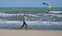 Una mujer camina por una playa de Rímini