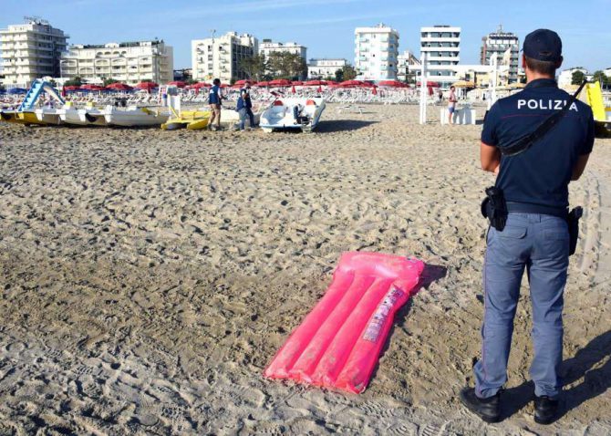 Policías inspeccionan un área donde una pandilla violó a una turista polaca y golpeó a su pareja, en una playa de Rimini, Italia, el sábado 26 de agosto de 2017.
