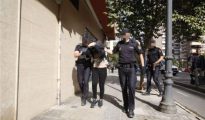 Los policías trasladan a la detenida por la muerte de su marido en una casa de Valencia.