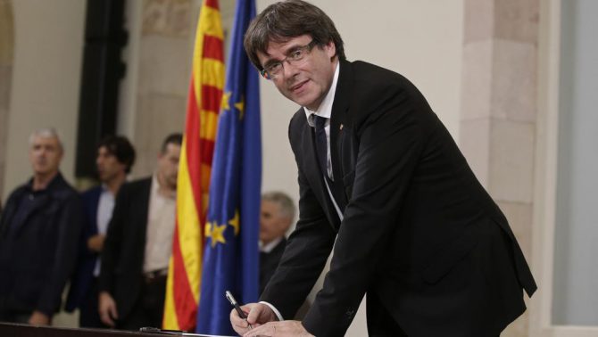 El president Puigdemont firmando la declaración (AP)