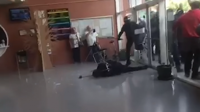 Un policía nacional yace en el suelo tras recibir un sillazo el 1-O