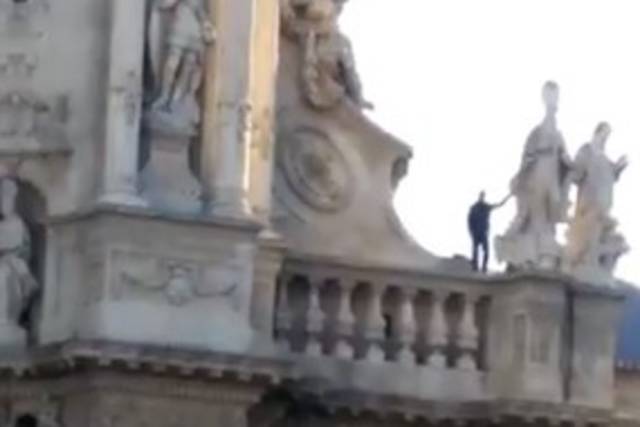 Un hombre se encarama a la fachada de la Catedral de Murcia