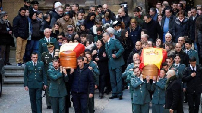  Con aplausos han sido recibidos y con aplausos han sido despedidos los féretros de Víctor Romero Pérez y Víctor Jesús Caballero de la iglesia de Santa María de Alcañiz (Teruel), donde se ha celebrado el funeral por estos dos guardias civiles muertos por los disparos del asesino al que perseguían. La familia, amigos, vecinos de Alcañiz y decenas de compañeros guardias civiles desplazados a la ciudad bajoaragonesa han despedido hoy a los dos jóvenes agentes, fallecidos a última hora del pasado jueves por los disparos del serbio Norbert Feher, a quien perseguían cuando acababa de matar también a tiros en una masía cercana a José Luis Iranzo, un vecino de Andorra (Teruel). La plaza de España, en la que está el Ayuntamiento donde ayer a última hora se instaló la capilla ardiente, no ha dejado de registrar trasiego durante toda la noche, de vecinos y guardias civiles que querían mostrar sus condolencias a las familias. Pero desde una hora antes del comienzo del funeral ya se congregaban en la antigua colegiata de Santa María de Alcañiz numerosos compañeros, visiblemente emocionados. Familiares y compañeros de los agentes han portado a hombros los féretros, recorriendo los escasos metros que separan el Ayuntamiento del templo en el que se ha celebrado la ceremonia. En medio de un silencio sepulcral, era posible oír con nitidez los lamentos de los familiares, como el del primero que ha entrado en la iglesia, abuelo de uno de los fallecidos, que lo ha hecho en silla de ruedas y visiblemente emocionado, mientras recordaba a su nieto y su juventud. A su llegada a las puertas de la iglesia, la Banda de Música de la Guardia Civil ha interpretado la marcha fúnebre y el himno de España, y a la salida han despedido a los agentes interpretando el himno de la Guardia Civil y la obra "La muerte nunca es el final". Víctor Romero, nacido en Teruel, de 30 años, estaba casado y había sido padre hace unos meses; Víctor Jesús Caballero, natural de Cádiz, nació en 1979. Iranzo, de 40 años, también estaba casado y tenía un hijo. Formaban parte de uno de los equipos ROCA que la Guardia Civil tiene distribuidos por todo el territorio nacional y cuya función consiste en combatir los robos en el entorno rural. Al funeral han asistido representantes policiales y militares de Teruel y Aragón, incluidos de los Mossos d'Esquadra y la agentes rurales franceses. También han acudido el Justicia de Aragón, consejeros del Gobierno de Aragón, y el presidente del Tribunal Superior de Justicia de Aragón, entre otros cargos judiciales de Aragón, Teruel y Alcañiz, así como autoridades militares y municipales. El delegado del Gobierno en Aragón, Gustavo Alcalde, ha dicho a los medios tras acabar la ceremonia que, en seis años en el cargo, este era "el día más triste" con la despedida a dos personas que habían "dado su vida en cumplimiento de su servicio". El delegado ha felicitado a la Guardia Civil por su trabajo, al igual que lo ha hecho ante los periodistas el consejero de Presidencia del Gobierno de Aragón, Vicente Guillén, que ha dado las "gracias" al cuerpo, por velar por la "seguridad" y por la "libertad" de todos. El asesino, Norbert Feher, fue detenido en la madrugada del viernes cerca de Mirambel (Teruel) después de un amplio despliegue de la Guardia Civil por la zona. Fue localizado tumbado en la carretera a pocos metros de la furgoneta pick up con la que había huido y con la que había sufrido un accidente, según indicaron a Efe fuentes de la Guardia Civil. Está previsto que mañana preste declaración en los juzgados de Alcañiz por videoconferencia a las 10:30 ante la juez de la Audiencia Nacional Carmen Lamela, según fuentes judiciales, para responder por la orden europea de detención que Italia emitió contra él. Después, previsiblemente lo hará ante la juez de Instrucción de Alcañiz por los tres asesinatos de Teruel.