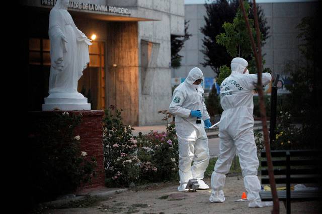 Agentes investigando los hechos junto a una iglesia de un vecindario de Chile.