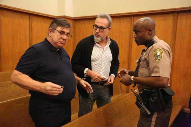 Luis Riu, en el centro, esposado tras su detención. MIAMI HERALD