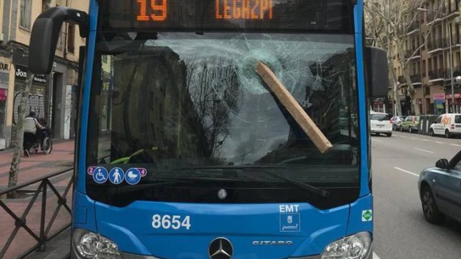 El tablón de madera ha quedado clavado en el cristal del autobús / @policiademadrid