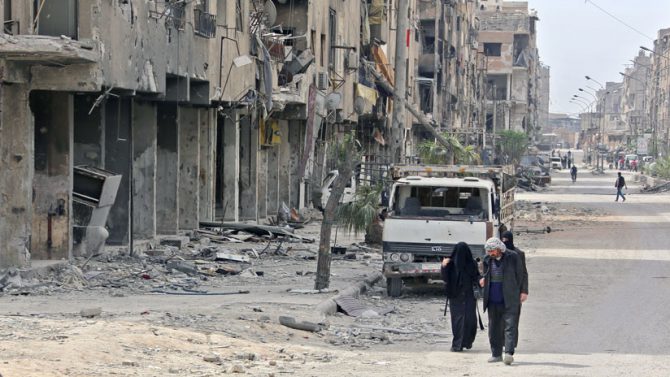 Civiles caminan en la antigua ciudad de Duma, en las afueras de Damasco, Siria, el 17 de abril de 2018.