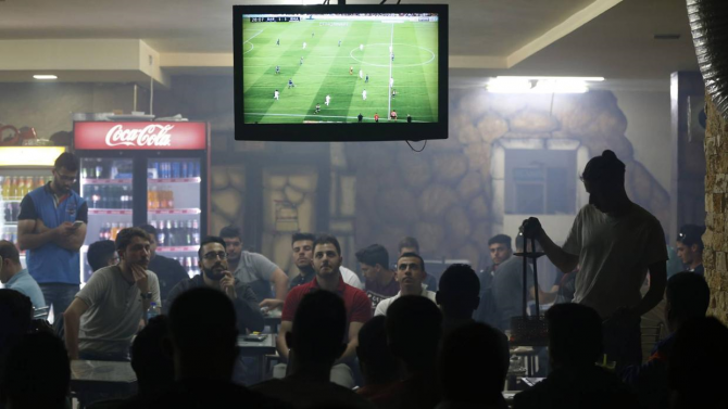 Palestinos ven un partido de fútbol en un bar en Ramallah