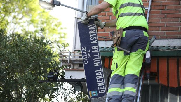 Un operario retira la placa de la calle de Millán Astray
