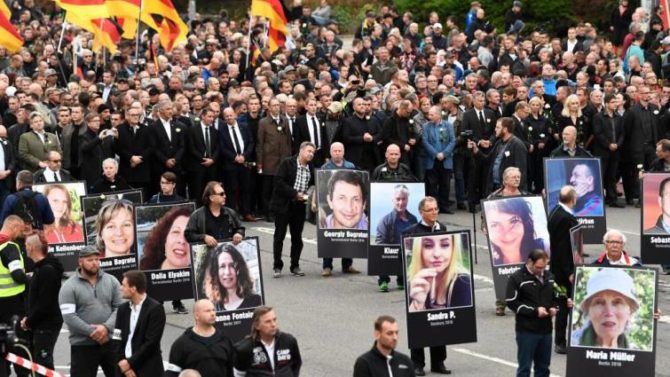 Participantes en la marcha de Chemnitz portan retratos de víctimas de ataques por parte de inmigrantes.