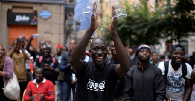Inmigrantes africanos recién llegados a España bailan durante una fiesta de bienvenida organizada por grupos vecinales.