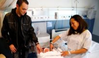 Karem y Joaquín miran a su hijo Derek, el primer madrileño nacido en 2018 en Madrid