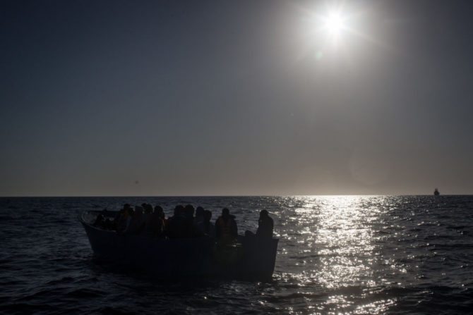 En la imagen, tomada en las inmediaciones de Lampedusa, Italia, inmigrantes a bordo de una patera aguardan a ser recogidos por el buque de salvamento Phoenix el 10 de junio de 2017. 