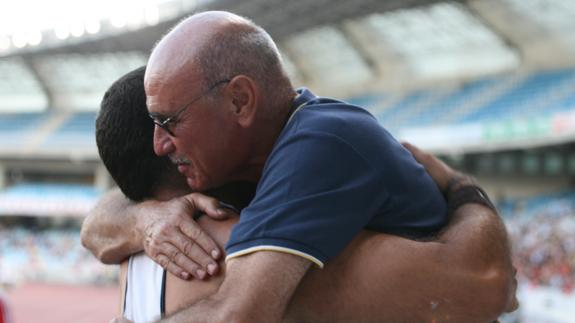 Millán abraza a un atleta.