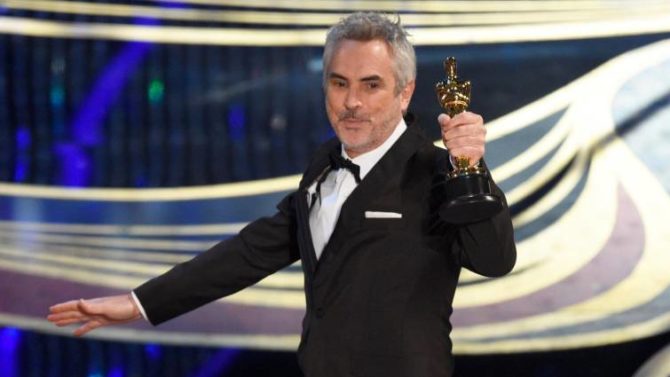 El director Alfonso Cuarón recoge uno de los Oscar logrados por su película “Roma” 
