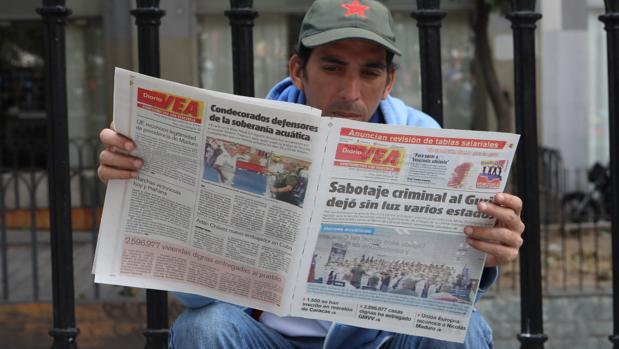 Un hombre lee un diario con titulares sobre el apagón eléctrico en Caracas (Venezuela)