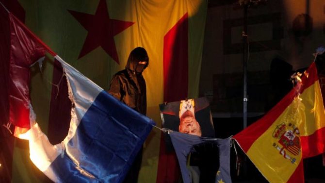 Miembros de la organización Arran, vinculada a la CUP, queman la bandera de España, Francia y la UE