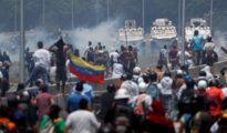 Grupos de manifestantes se enfrentan a las tanquetas de las fuerzas bolivarianas en la proximidades de la base aérea de La Carlota